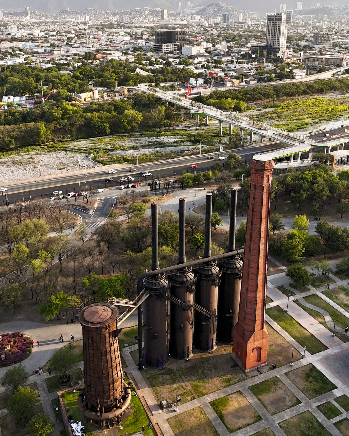 Aerial view of Parque Fundidora, with the chimneys and blast furnace rising over Monterrey's urban park